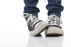 Vintage, antique athletic shoes on a white background with jeans